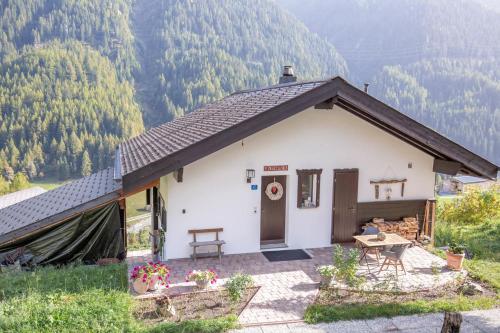a small white house with a table in front of it at Chalet La Neuf in Blitzingen