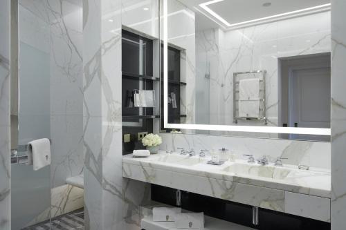 a white bathroom with a sink and a mirror at H&ocirc;tel de Paris Monte-Carlo in Monte Carlo