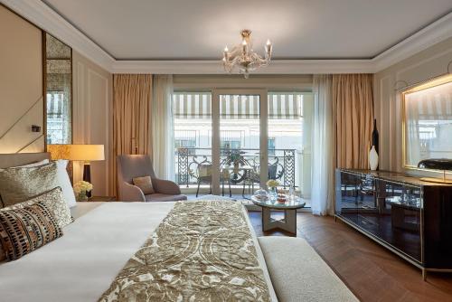 a bedroom with a large bed and a living room at Hôtel de Paris Monte-Carlo in Monte Carlo