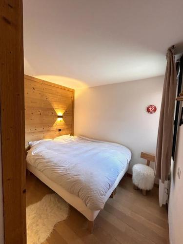 une chambre avec un grand lit avec une tête de lit en bois dans l'établissement Stijlvol 4-kamerappartement in Valmorel aan de piste, à Valmorel