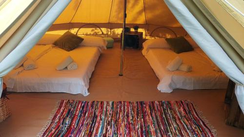 a room with three beds in a tent with a rug at Camping Llavorsi in Llavorsí