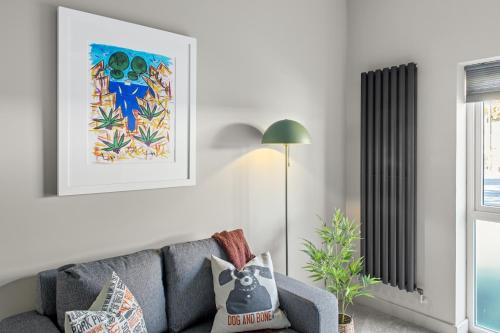 a living room with a gray couch and a lamp at Brand New 1-Bed Flat Steps from Clifton NTU Campus in Nottingham
