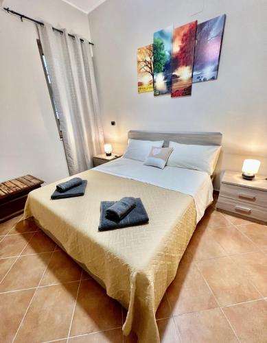 a bedroom with a large bed with two towels on it at Tutti i Comfort Giuliano's Apartment in Messina