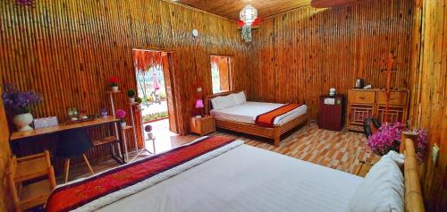 a bedroom with a bed in a room with wooden walls at Quoc Khanh Bamboo Homestay in Ninh Binh