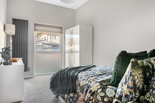 a bedroom with a bed with a green comforter at Brand New 1-Bed Flat Steps from Clifton NTU Campus in Nottingham