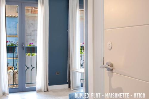 Habitación con puerta azul y ventana en UNIQ flats, en Alicante