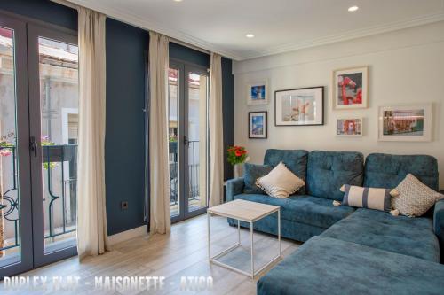 a living room with a blue couch and a table at UNIQ flats in Alicante