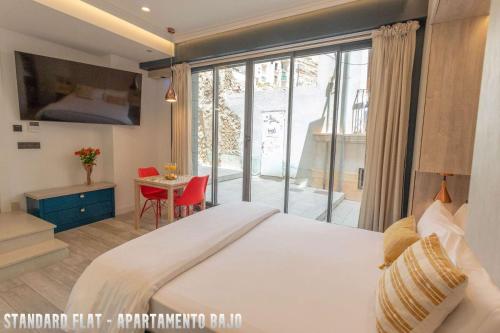 a bedroom with a large bed and a table with chairs at UNIQ flats in Alicante