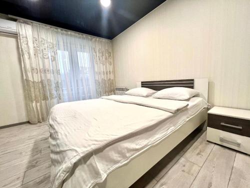 um quarto com uma cama grande e uma janela em ApartPoltava 2 ОКРЕМІ кімнати, новобудова, ДВА великих ліжка ЦЕНТР, КОРПУСНИЙ САД em Poltava