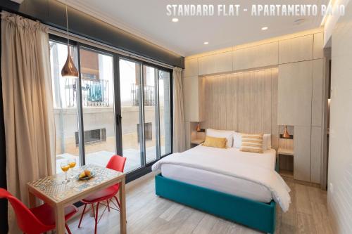 um quarto de hotel com uma cama, uma mesa e uma mesa em UNIQ flats em Alicante