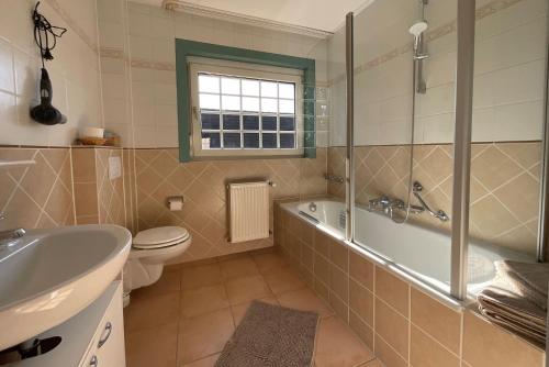 a bathroom with a tub and a toilet and a sink at Hotel St. Paulushof 