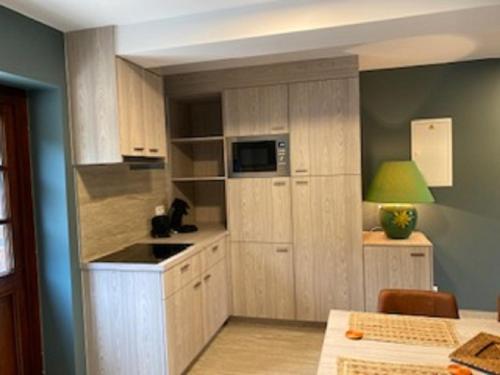 a small kitchen with wooden cabinets and a microwave at Hotel IL Castellino in Chaudfontaine