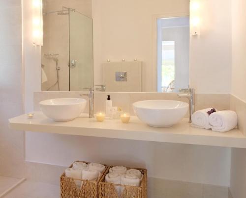 a bathroom with two sinks and a mirror and towels at The Saints - Terrace House in Nisaki