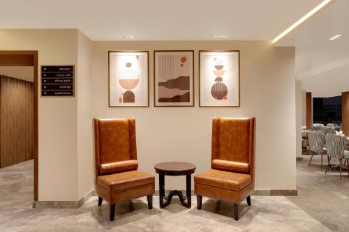a waiting room with two chairs and a table at Lemon Tree Suites, Whitefield, Bengaluru in Bengaluru