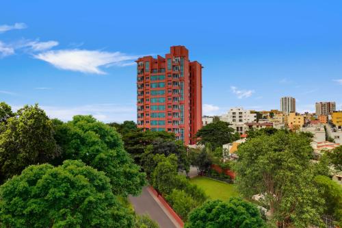 uma vista para uma cidade com um alto edifício vermelho em Lemon Tree Suites, Whitefield, Bengaluru em Bangalore
