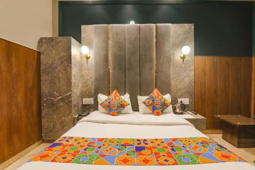 um quarto com uma cama grande e um cobertor colorido em FabHotel Royal Palm Inn em Faizābād