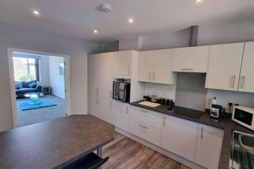 a kitchen with white cabinets and a counter top at Cornish Village Getaway in Gwennap