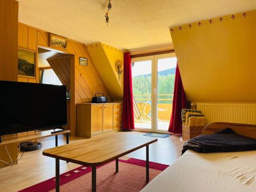 een woonkamer met een televisie en een tafel bij Ferienwohnung Sonnleiten in Puchberg am Schneeberg