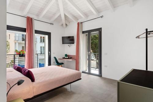 Un dormitorio blanco con una cama y un balcón. en Double D House, en Olbia