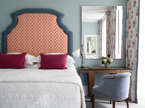 1 dormitorio con cama, silla y espejo en Number Sixteen, Firmdale Hotels, en Londres