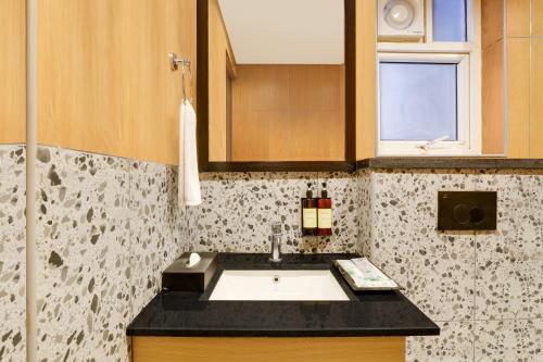 a bathroom with a sink and a window at Lemon Tree Suites, Whitefield, Bengaluru in Bengaluru