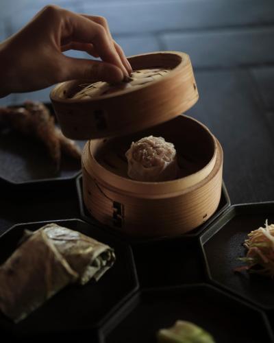 a person is putting food in a wooden bowl at Numazu Club in Numazu