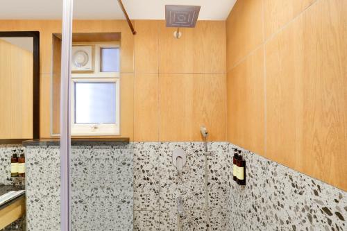 a bathroom with a shower and a window at Lemon Tree Suites, Whitefield, Bengaluru in Bengaluru