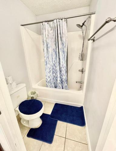 baño con aseo y alfombra azul en Serene 2-bedroom rental unit w/ Free Parking, en Nashville