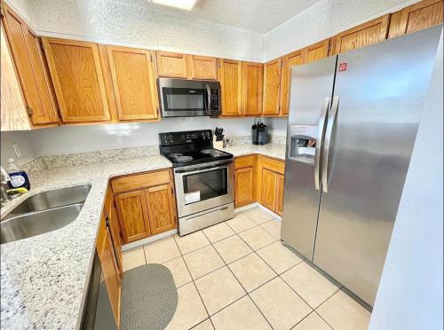 una cocina con armarios de madera y electrodomésticos de acero inoxidable en Serene 2-bedroom rental unit w/ Free Parking, en Nashville