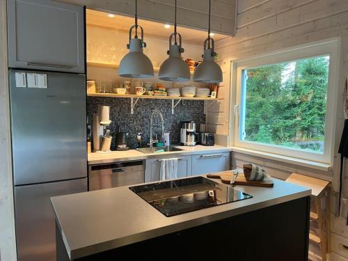a kitchen with a stainless steel refrigerator and a sink at Välkommen till vårt vackra hus in Gnesta