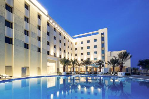 a large swimming pool in front of a hotel at Mercure Sohar in Sohar