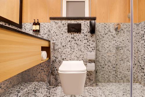 a bathroom with a toilet and a shower at Lemon Tree Suites, Whitefield, Bengaluru in Bengaluru