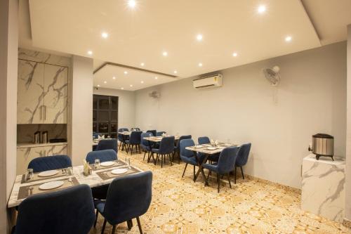 a dining room with tables and blue chairs at Regalia Grand By Delight Stay in Amritsar