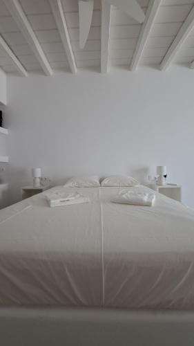 a large white bed in a white room at Spice Suites-Lime in Amorgos