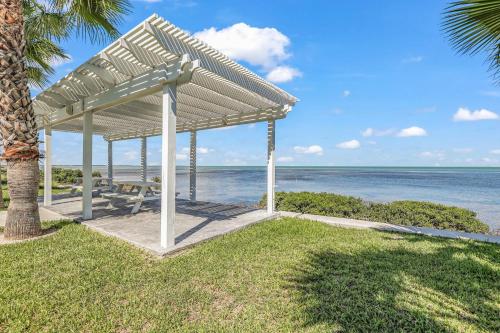 a pavilion at the beach with the ocean in the background at Bayfront Cottage- Pool - Hot Tub - Close to Beach in Port Isabel
