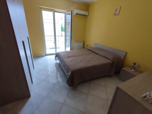 - une chambre avec un lit et une grande fenêtre dans l'établissement Casa Vacanze Il Tramonto Spadafora, à Spadafora