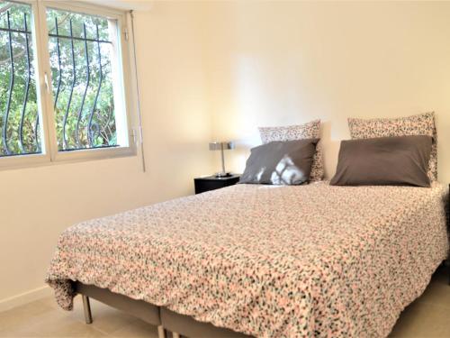1 dormitorio con cama y ventana en Appartement Cavalaire-sur-Mer, 2 pièces, 4 personnes - FR-1-226B-56, en Cavalaire-sur-Mer