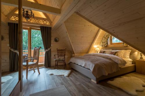 sypialnia z łóżkiem w drewnianym domu w obiekcie Aparthotel Bambi w Zakopanem