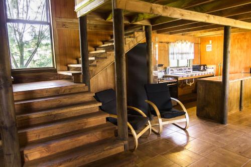 a staircase in a house with two chairs and a kitchen at Cabañas Tokerau in Hanga Roa