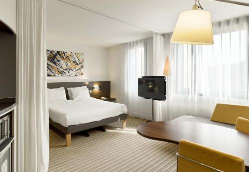 ロワシー・アン・フランスにあるB&B HOTEL Paris Grand Roissy CDG Aéroportのベッドとテーブルが備わるホテルルームです。