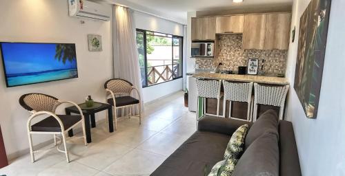 uma sala de estar com um sofá e uma cozinha em Peco Paradise Cumbuco Ap119 em Cumbuco