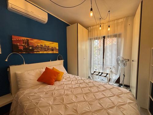 1 dormitorio con 1 cama con almohadas de color naranja en Casa de Chicca - Cute Apartment near Lake Nemi en Genzano di Roma