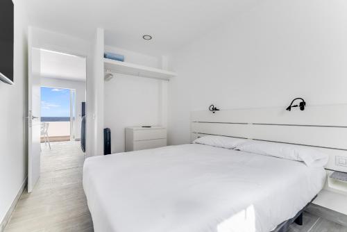 Home2Book Marly Ocean View San Andrés Beach في أروكاس: غرفة نوم بيضاء مع سرير كبير ونافذة