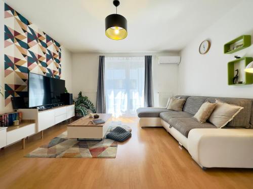 a living room with a couch and a tv at Corvin City Apartment - FREE PARKING- in Budapest