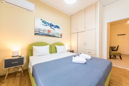 sypialnia z niebiesko-białym łóżkiem i biurkiem w obiekcie Over The Town Urban 1BR Apt. 7' to Thiseio Metro w Atenach