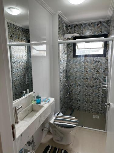 uma casa de banho com um chuveiro, um WC e um lavatório. em Hostel APÊ DO CRIS em Florianópolis