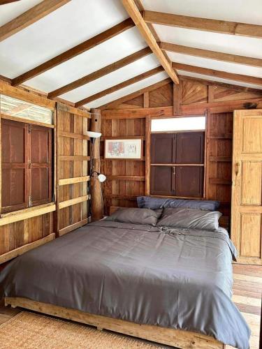 uma cama grande num quarto com paredes de madeira em Wind em Kalutara
