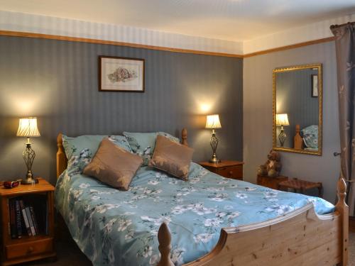 a bedroom with a bed with a blue comforter at Second Cottage in Cottingham