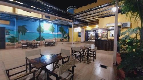 a restaurant with tables and chairs and a large mural at Hotel Villa in San Juan del Paraná