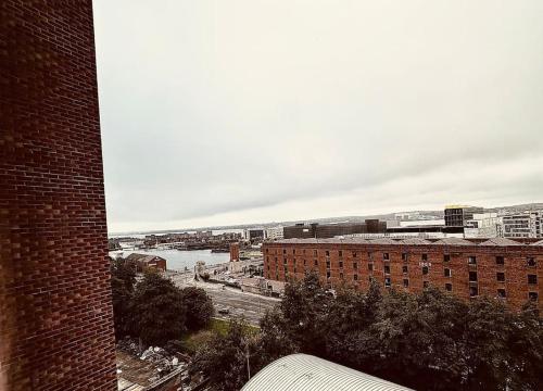 a view of a city with a river and buildings at BRAND NEW 5 STAR LUXURY 2 BEDROOM APARTMENT, SLEEPS 6, CENTRAL, WiFI, BIG SMART TV, ALEXA SPEAKERS, EASY ACCESS LOCK BOX ENTRY! in Liverpool